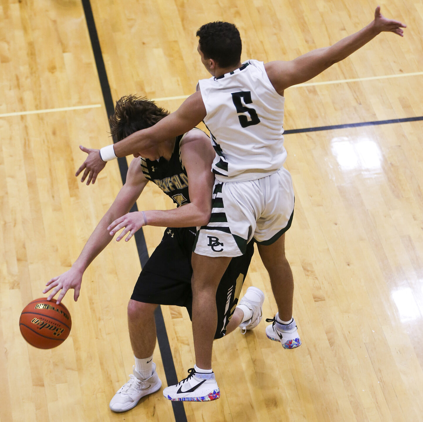 Hunter Stone dribbles underneath Billings Central guard Junior Brackenridge